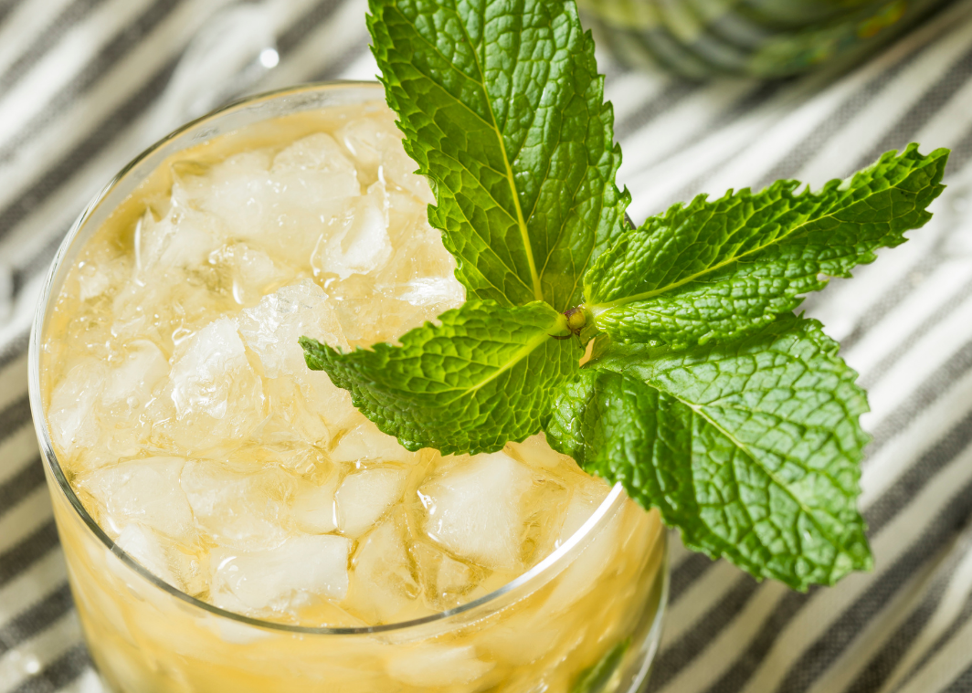 Kohana Cold Brew Mint Julep in a glass with a fresh basil leaf