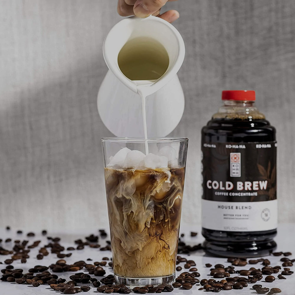 Kohana Cold Brew Concentrate House Blend bottle with glass being filled with cold brew and milk